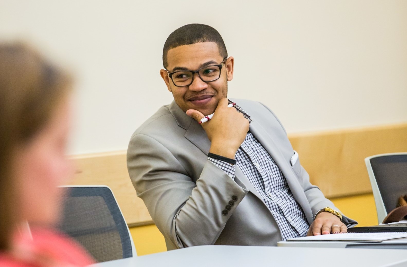 male student smiling in business class