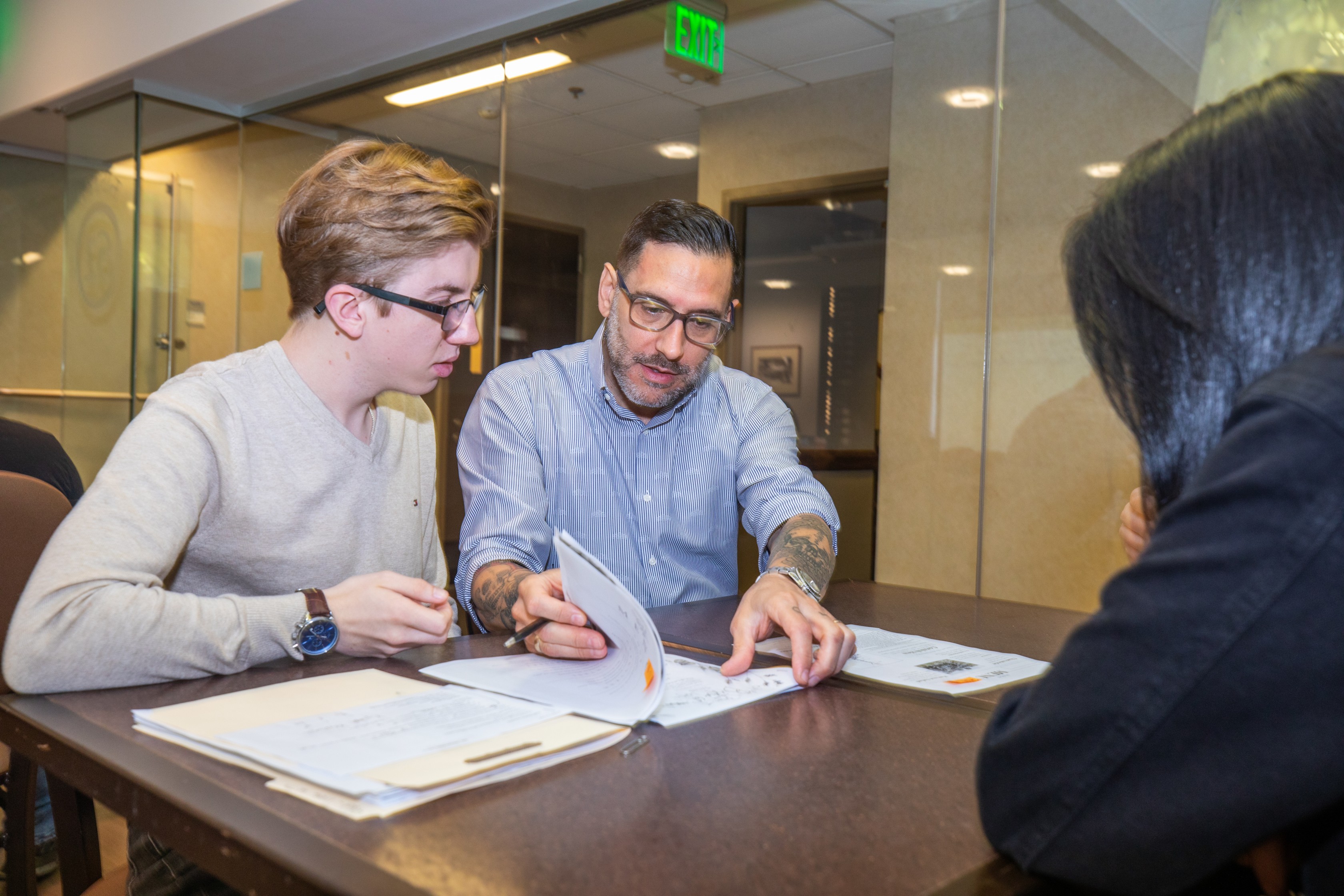 male college student filling our paperwork with advisor