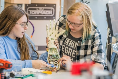 Engineering students working on components for a robotic hand.