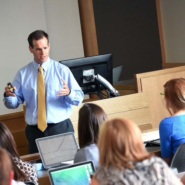 A classroom scene at JWU, with multiple students listening to a professor.