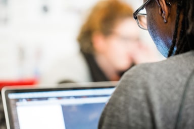 Student staring at data analysis on a computer screen.