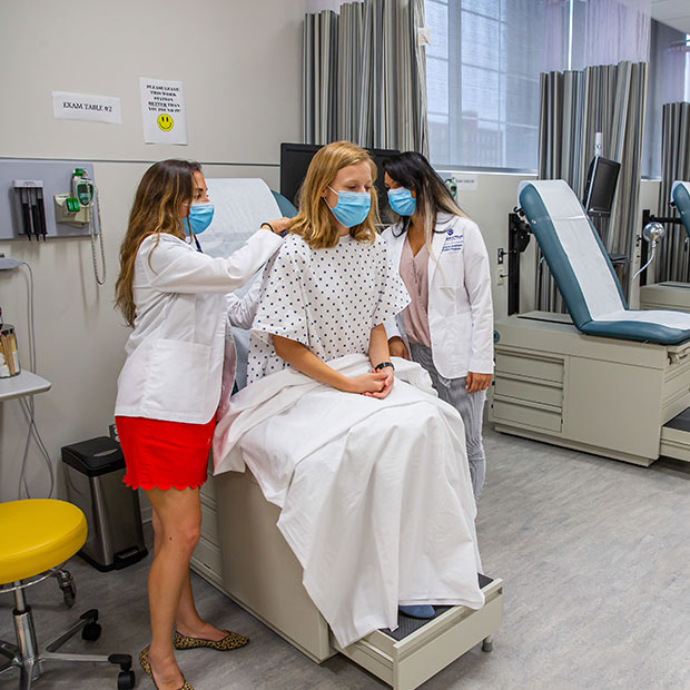 Physician Assistant students working with a patient.