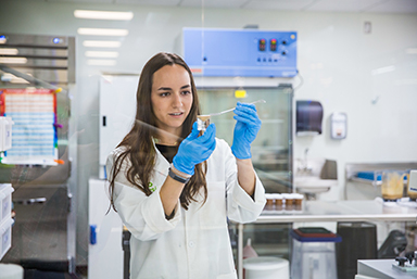 A student examining a sample in a lab