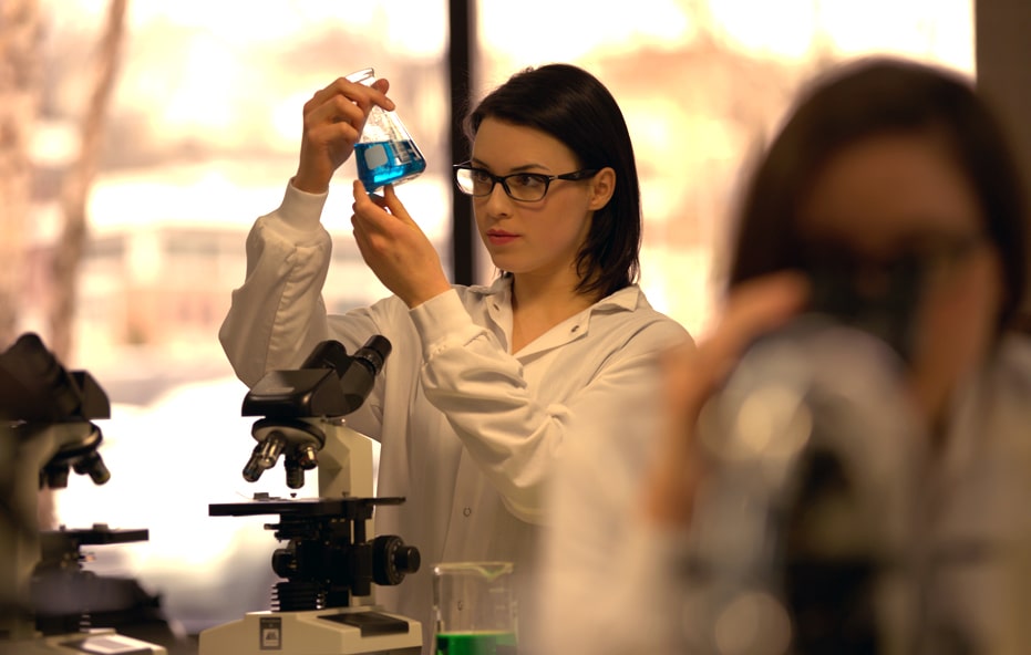 Student holding up a liquid sample in a beaker.