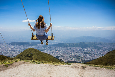 A JWU student swinging on a swing that overlooks a vista in Equador