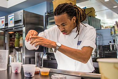Student in beverage lab pouring a drink