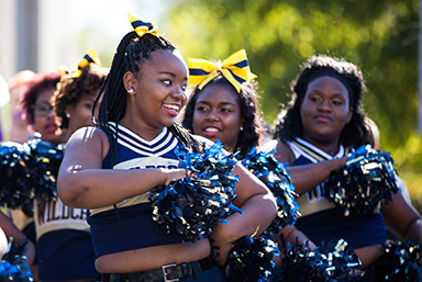 Student cheerleaders preforming during a parade on campus