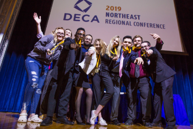 Group of students celebrating their DECA Northeast regional conference win in 2019