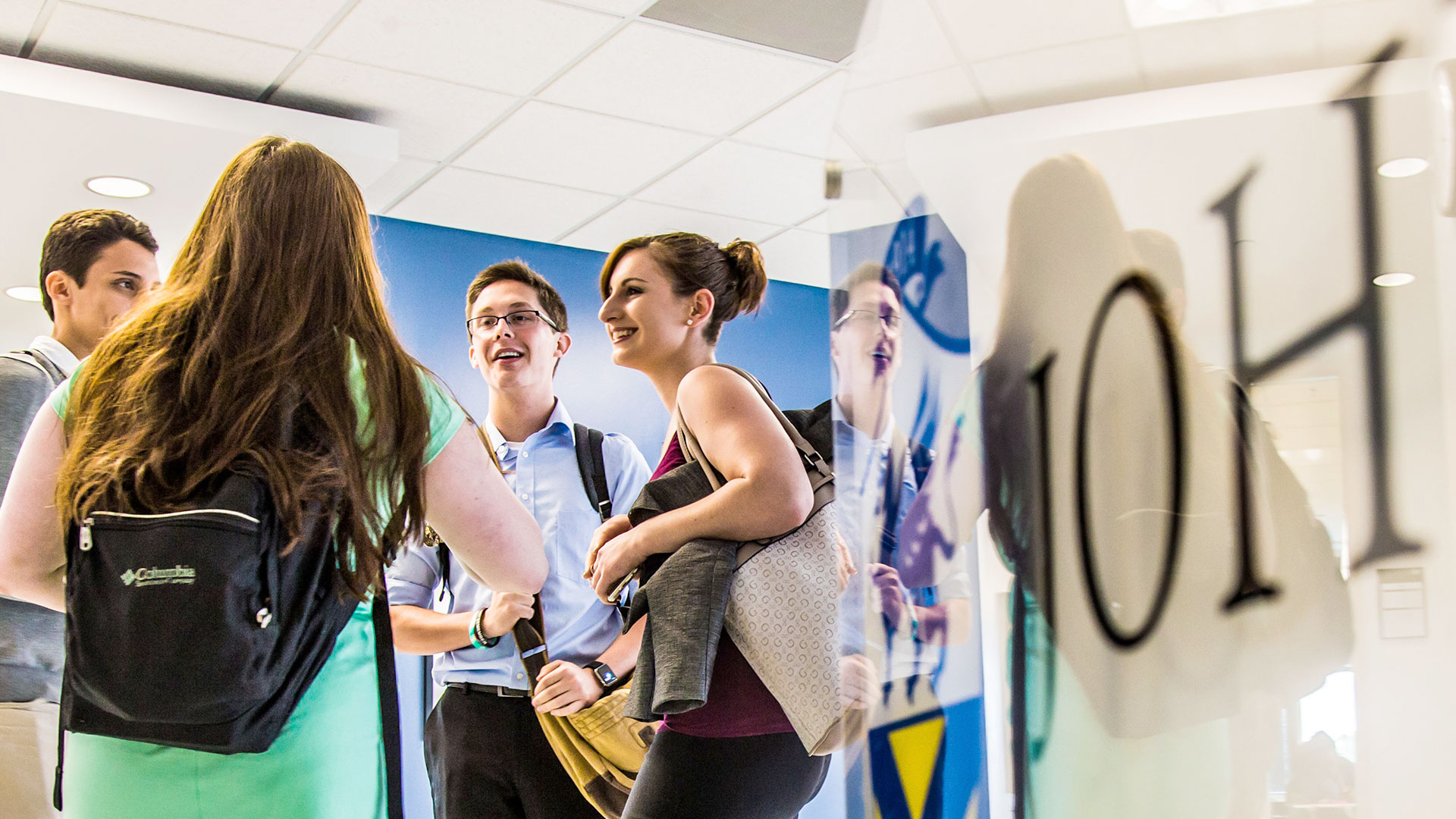 Group of students talk in the hallway of an academic building