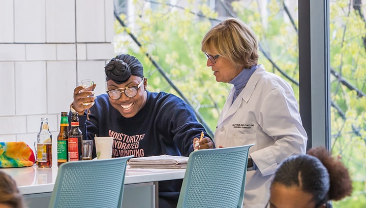 Professor interacting with a student in a Charlotte classroom.