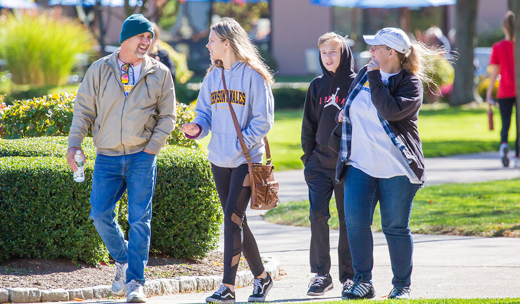 Family of four walks through campus