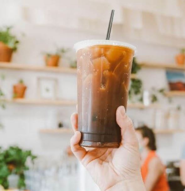 holding ice coffee at coffee shop