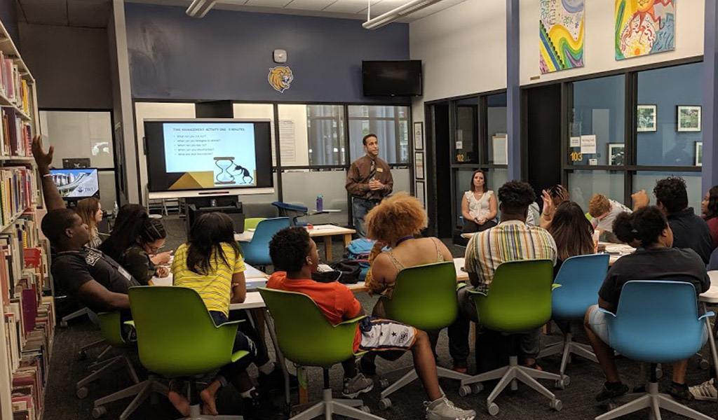 JWU Charlotte professor lecturing to a full classroom.