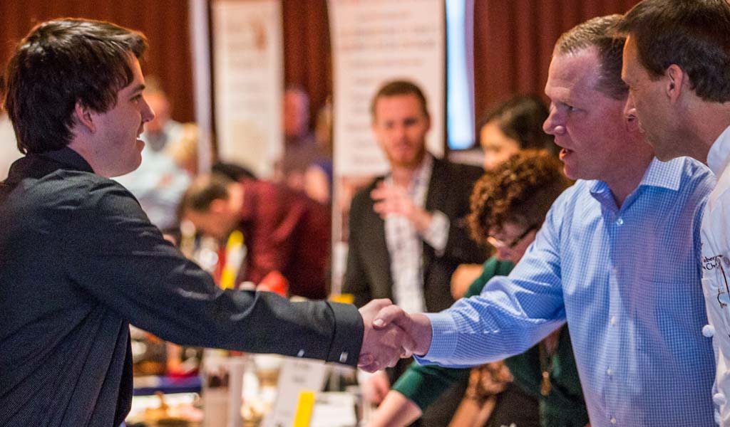 Student shaking hands at a JWU career fair