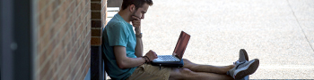 Student working on laptop outside