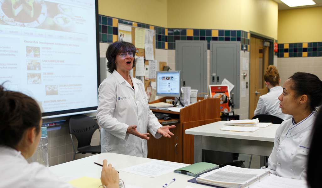 Female teacher leading a culinary science class. 