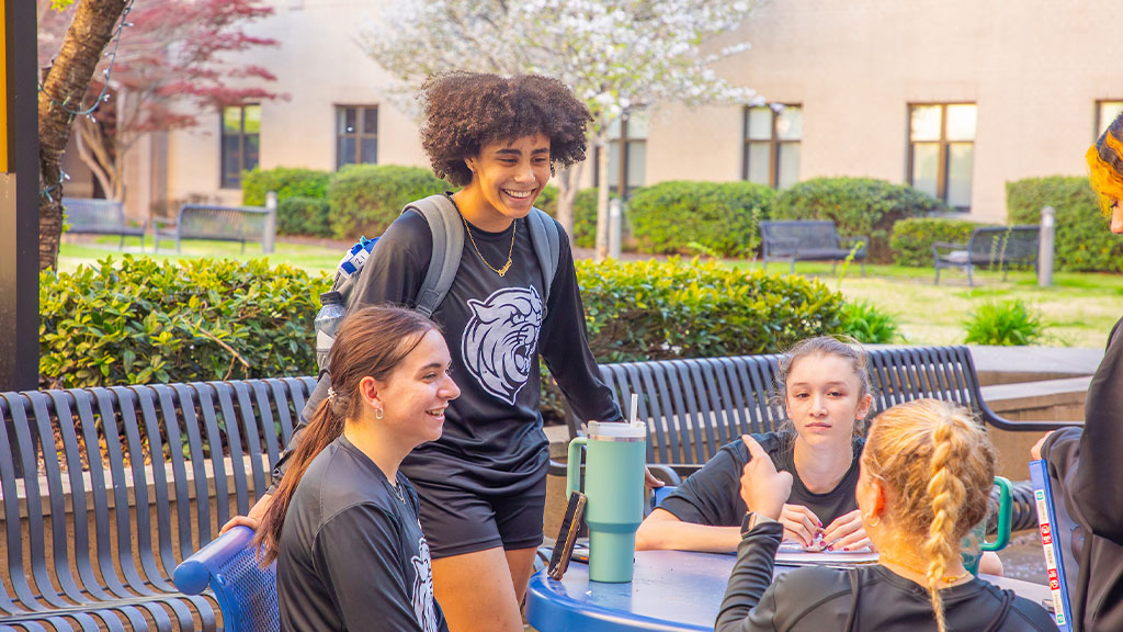 group of students standing outside of the wildcat center