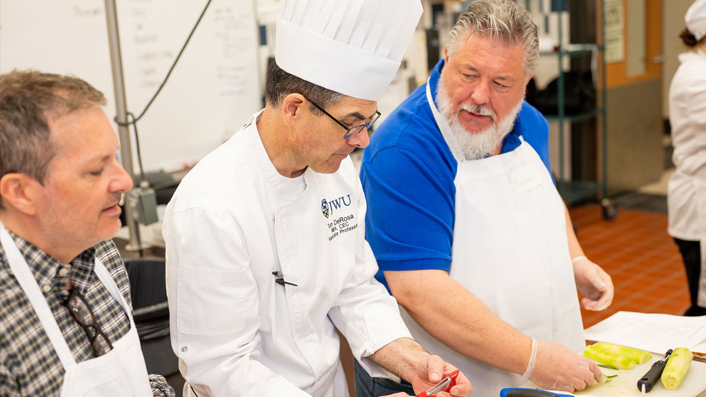 Charlotte Kitchen Academy students working with Chef DeRosa.