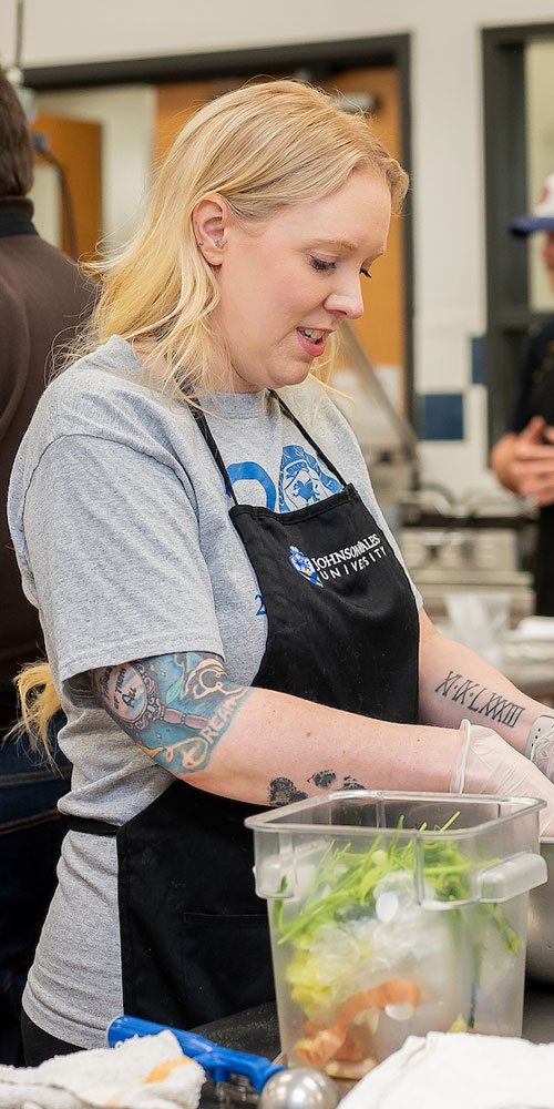 A cooking class student preps a dish. 