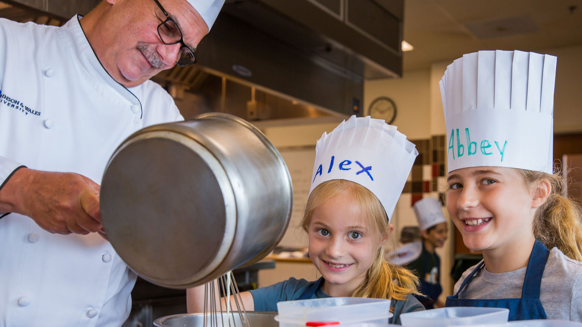 Chef Dion demonstrates cooking techniques during Summer Camp.