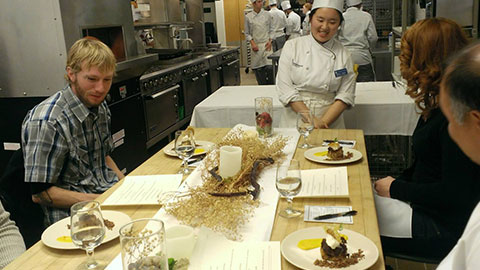 Guests sit down to a meal created by student chefs.