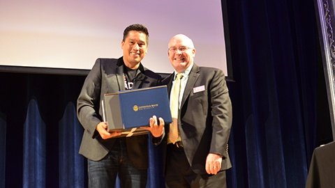 Bruce Poon Tip receiving honorary certificate from Dean Paul McVety.