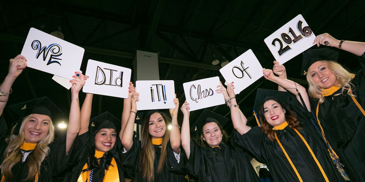 Soon-to-be JWU Denver grads hold up signs reading, “We Did It! Class of 2016.”
