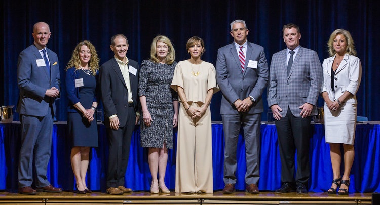 Guests and JWU Leadership pose for a group shooting the auditorium.