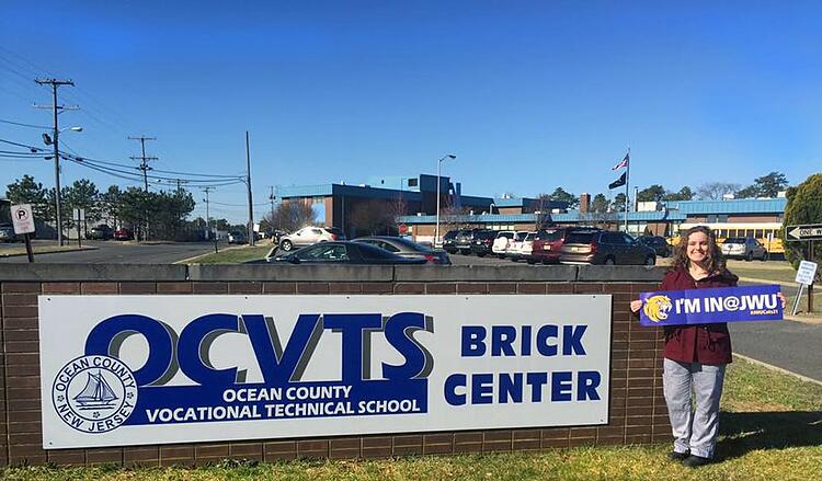 Providence Culinary Student Juliet Faas holds up her “I’m in at JWU” banner outside Ocean County vocational Technical School after being accepted to JWU.