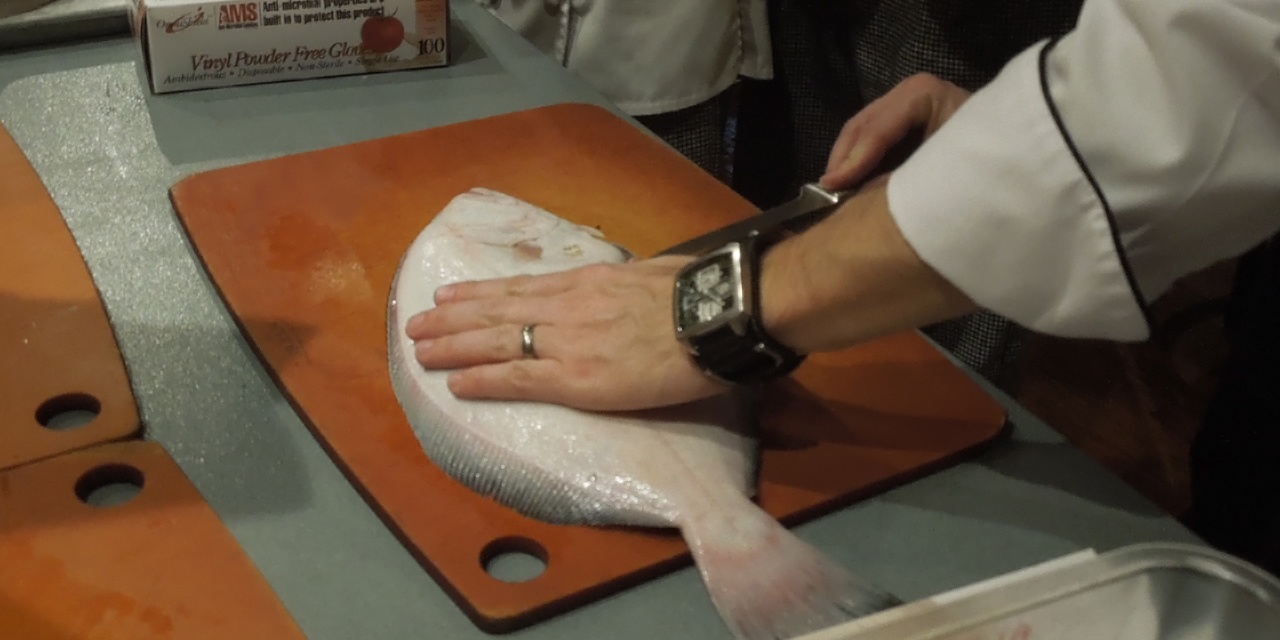 Demonstrating how to fillet a fish.