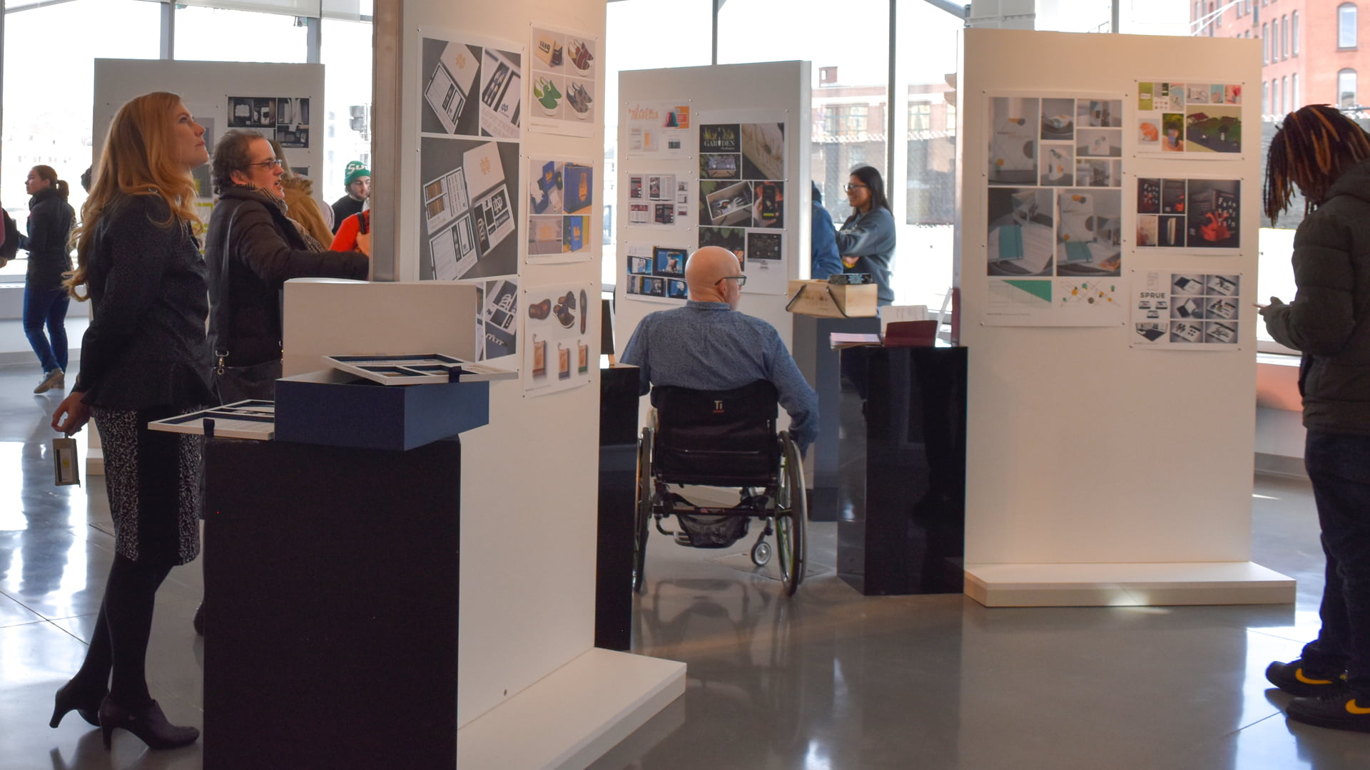 Faculty and staff look over exhibits of students' work. 