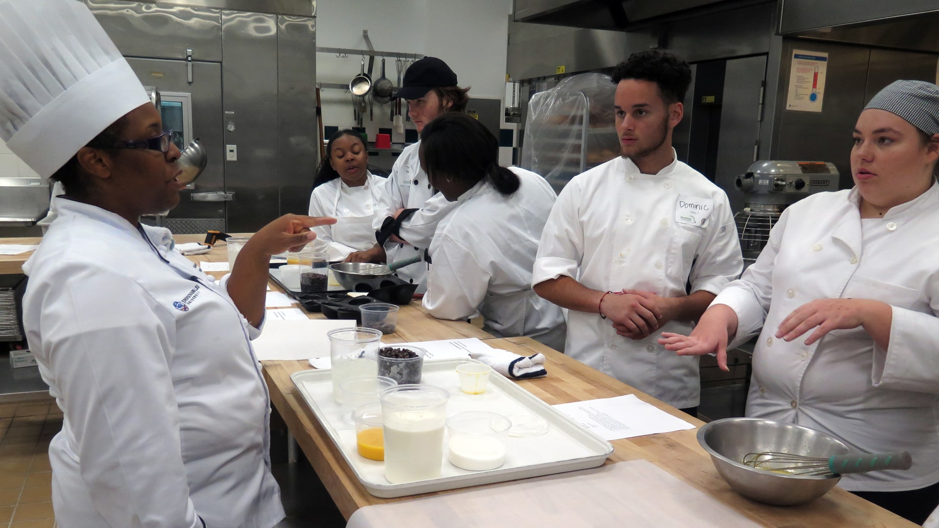 High School students learning culinary skills in JWU culinary lab.