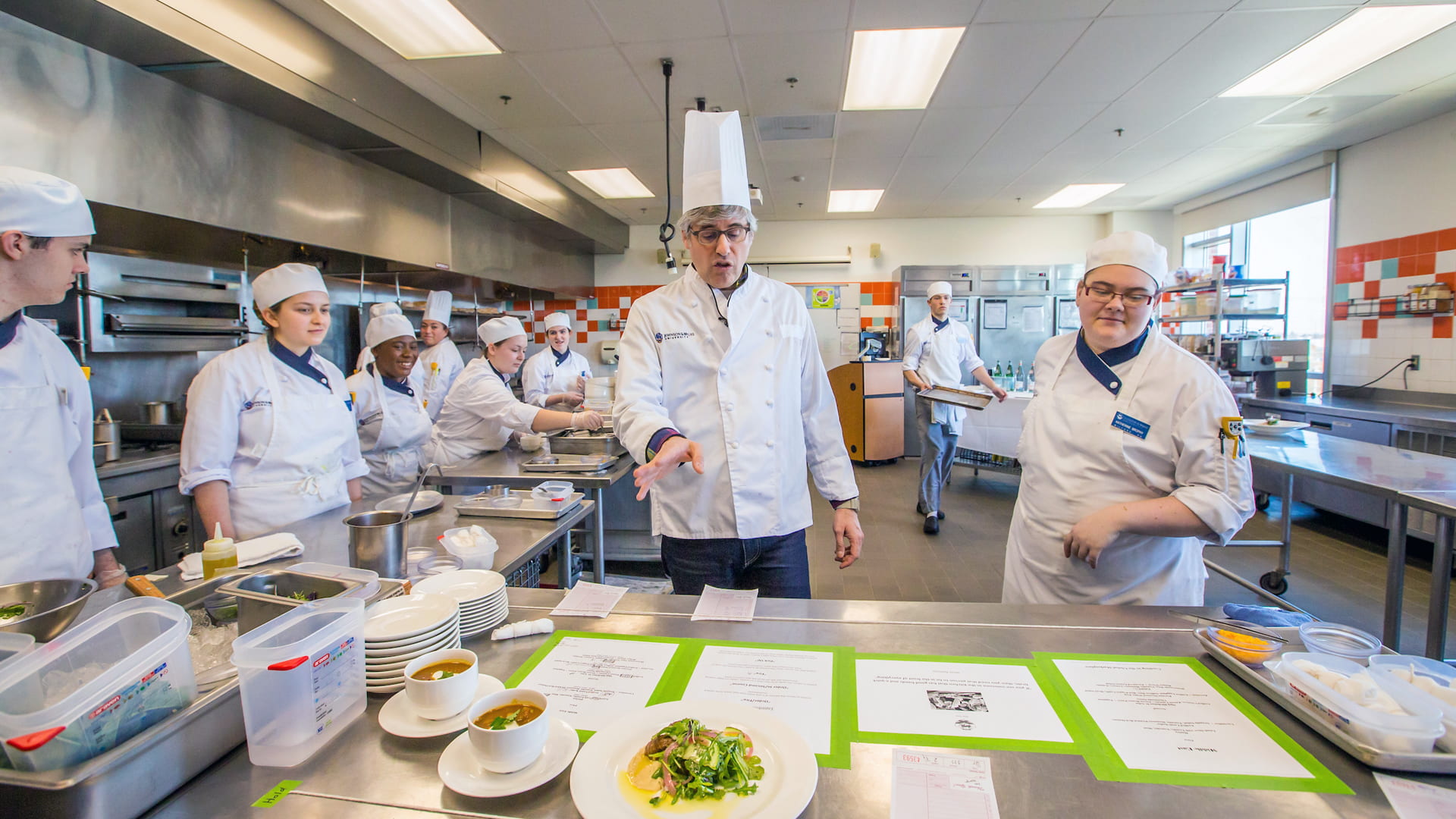Mo Rocca with JWU students in a culinary lab