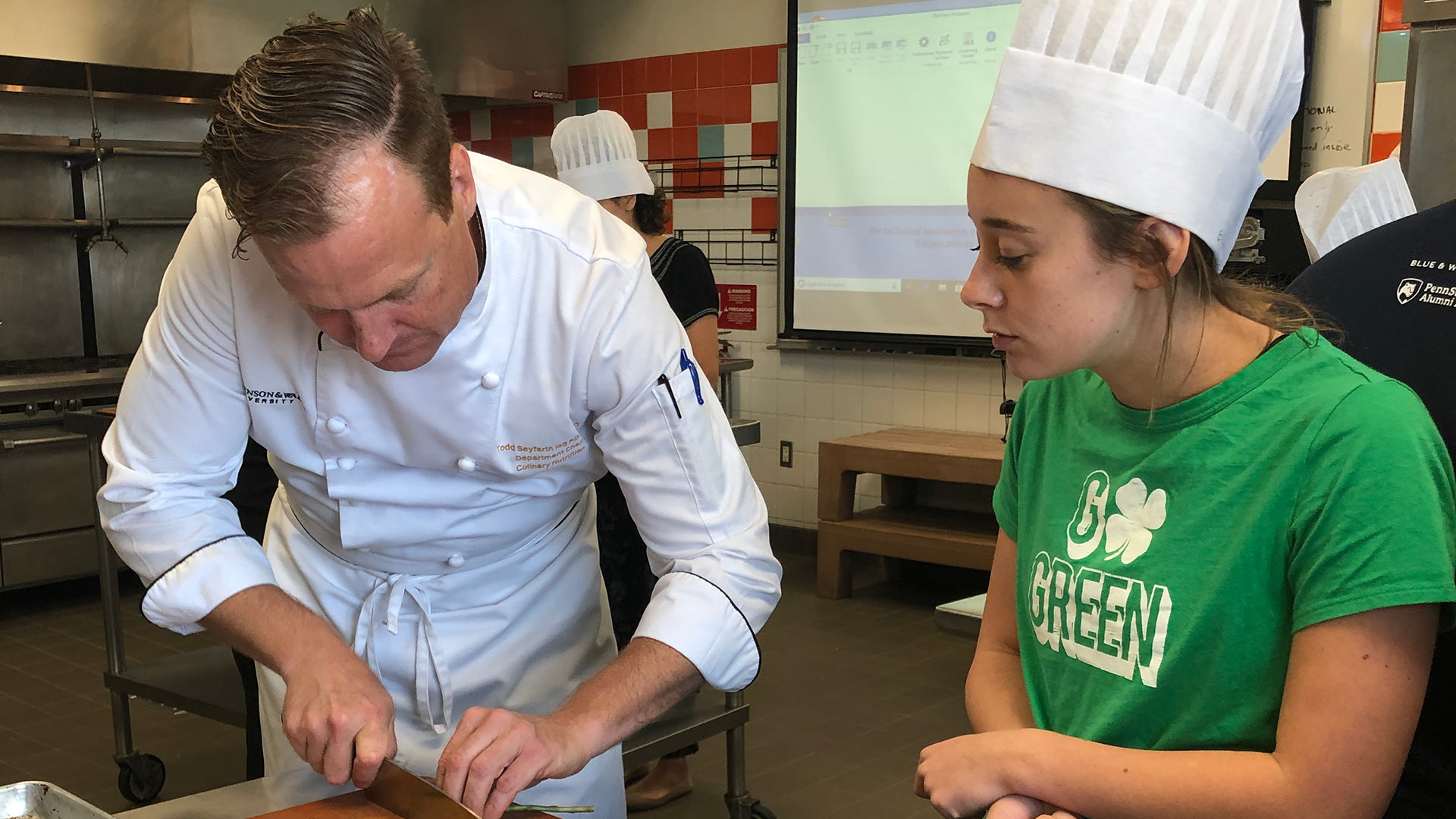 Chef Todd Seyfarth showing a student the proper way to cut.