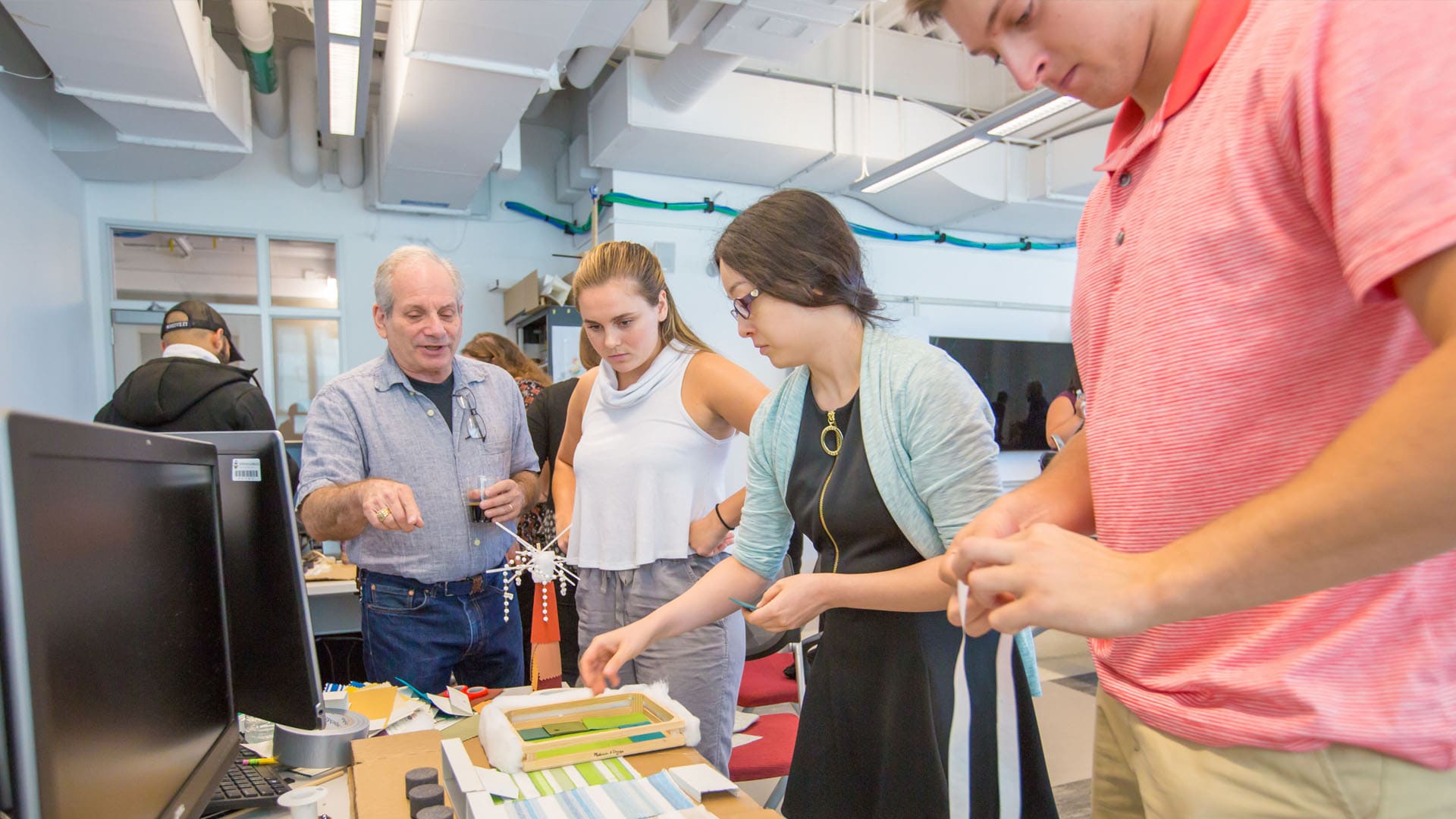 A student group discussing their project with Charlie Fishbein.