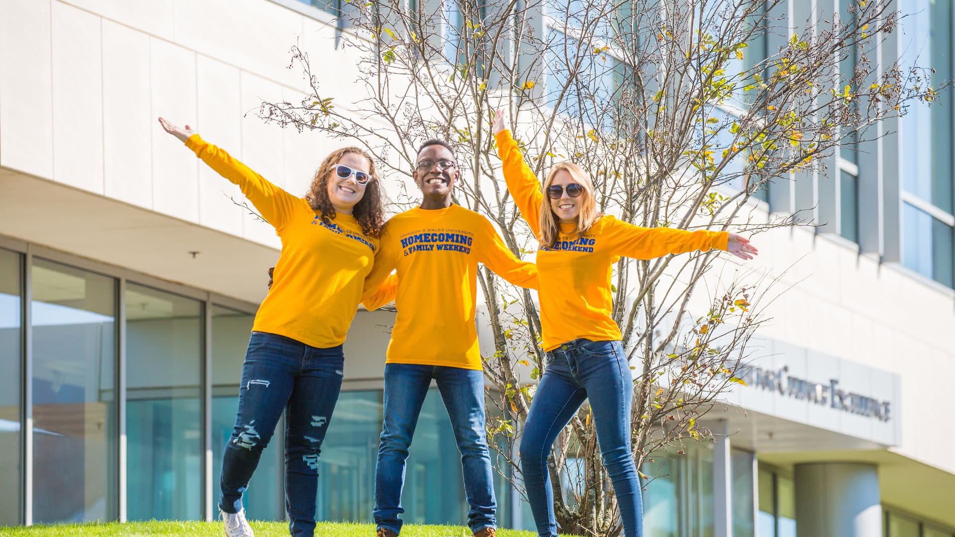 Trio of JWU students in front of the Cuisinart Center for Culinary Excellence at JWU Providence's Harborside Campus.