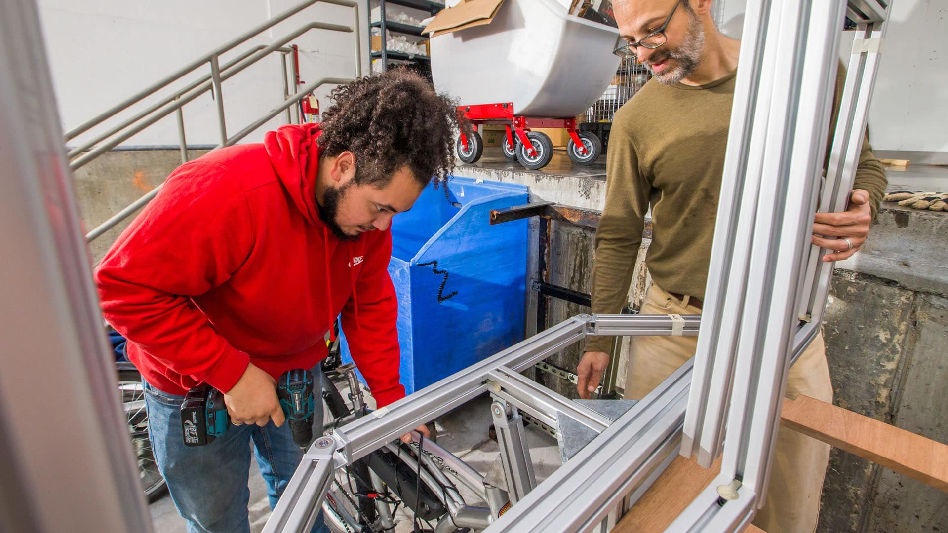 Sebastian Silva ’20 and Associate Professor Jonathan Harris working on their solar-powered delivery bike.
