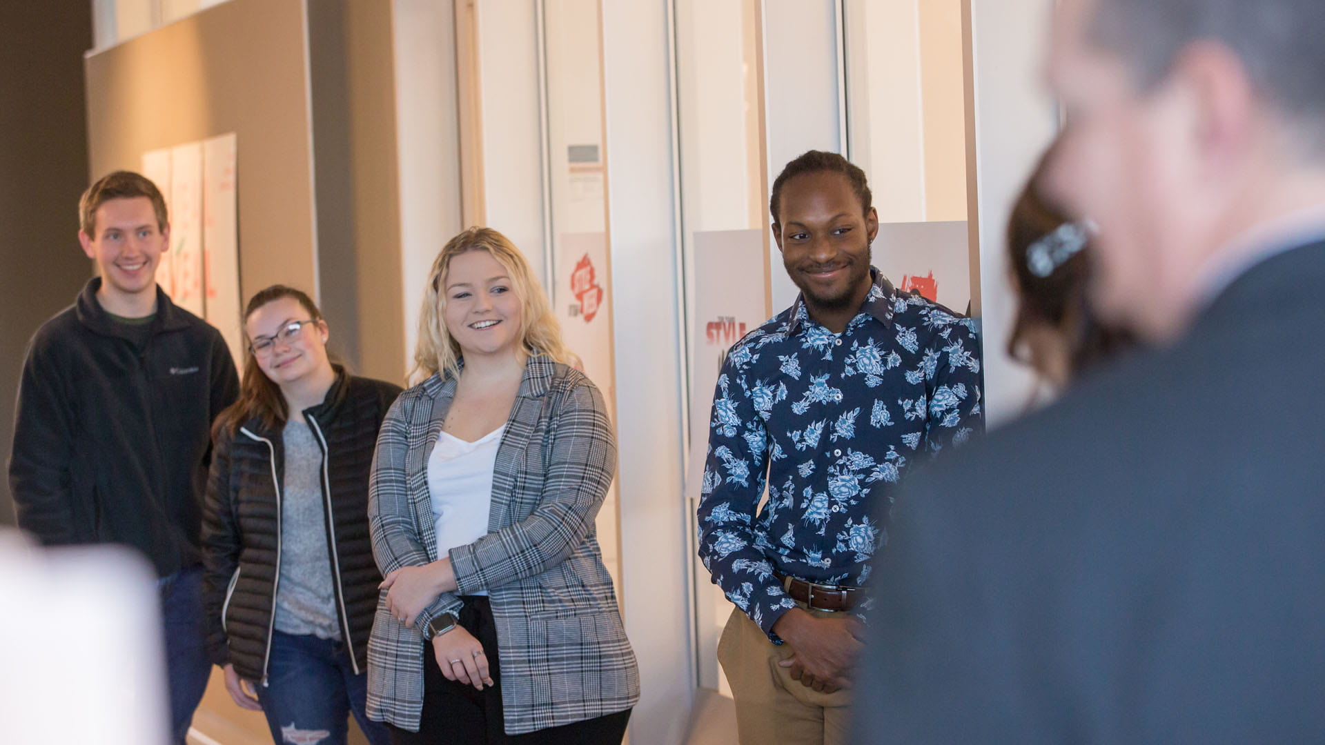 The student designers look on during the event.