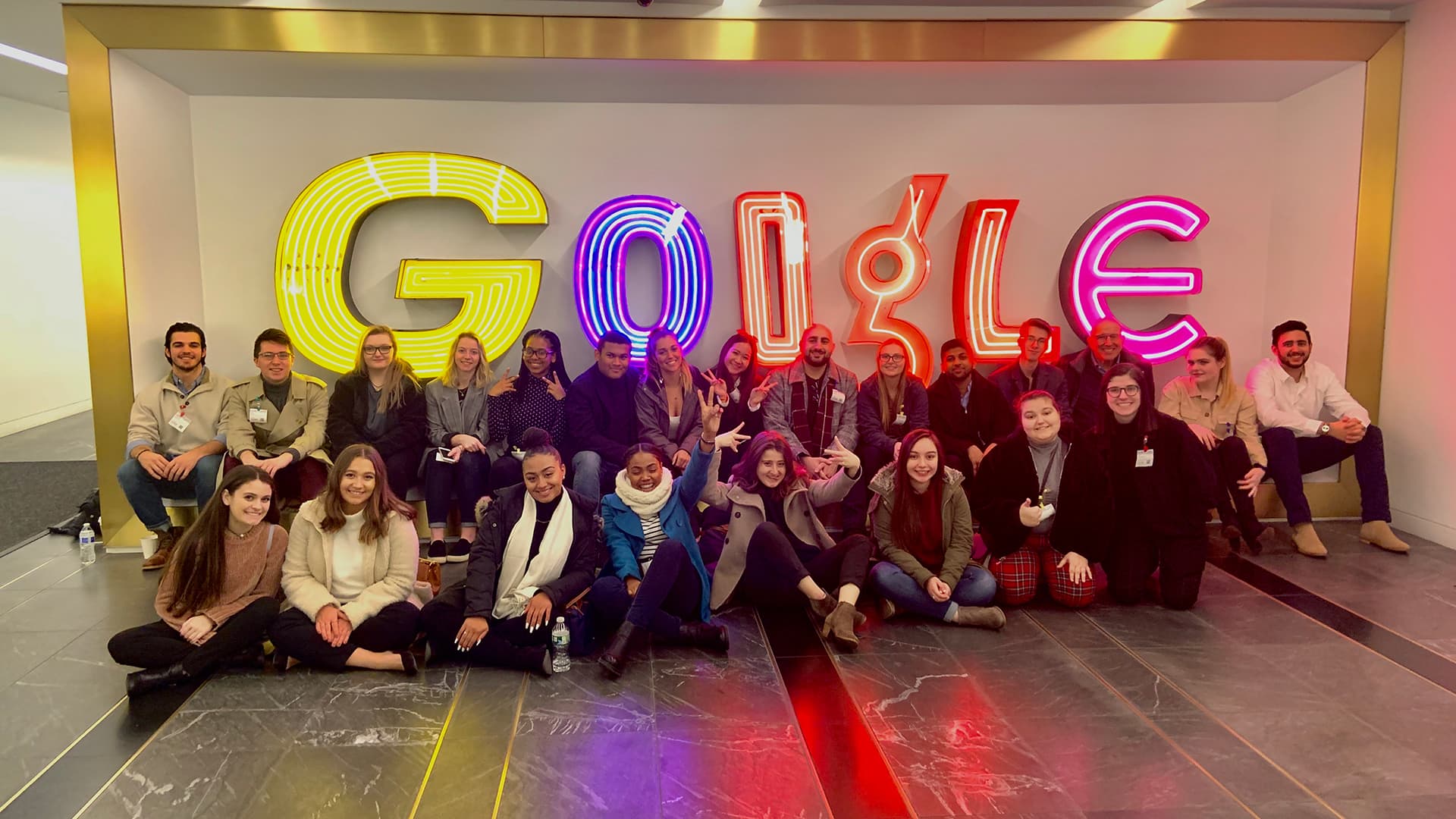 Student group in front of Google neon sign