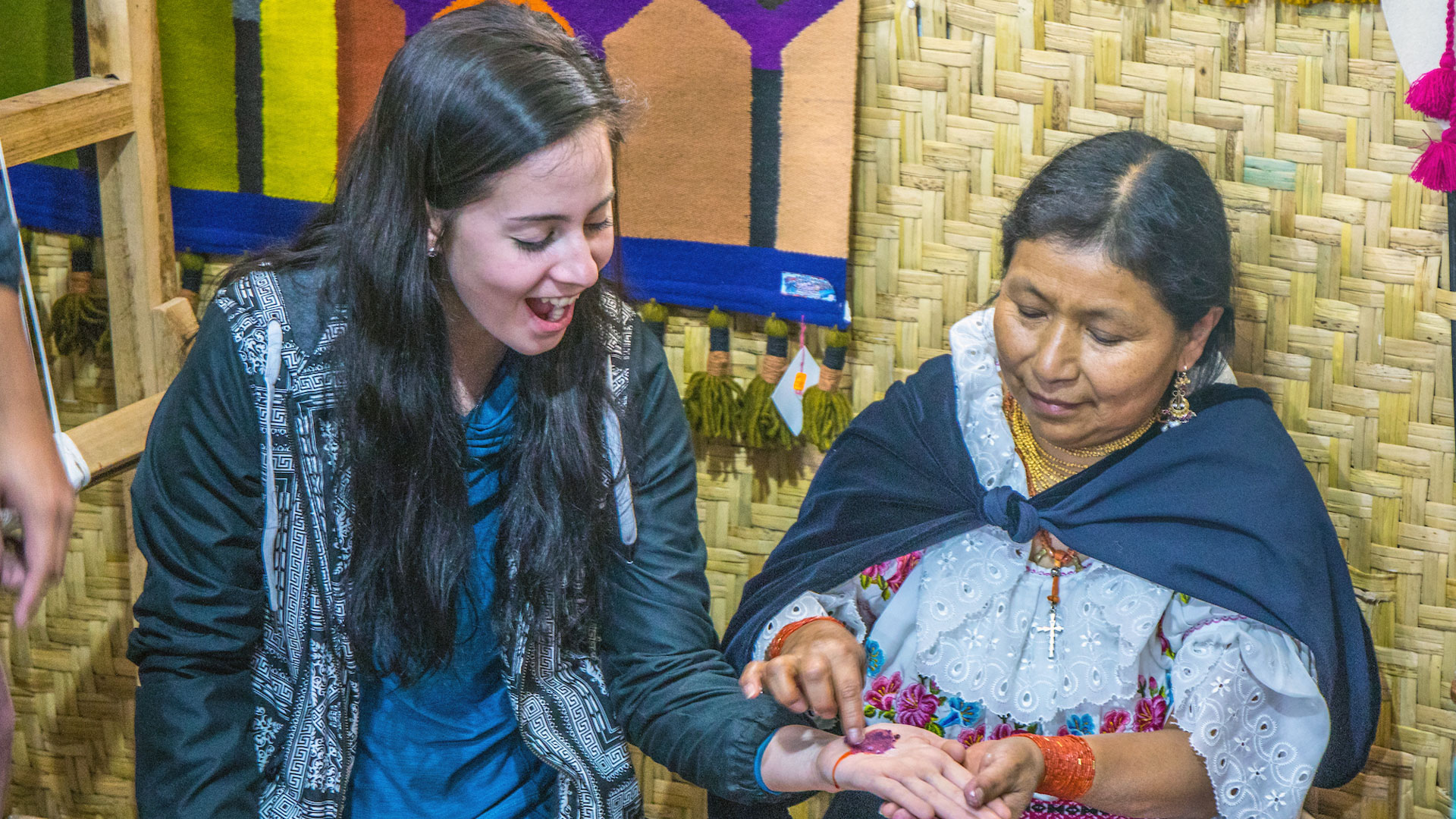 A JWU student gets her hand painted in a traditional folk art style in Ecuador