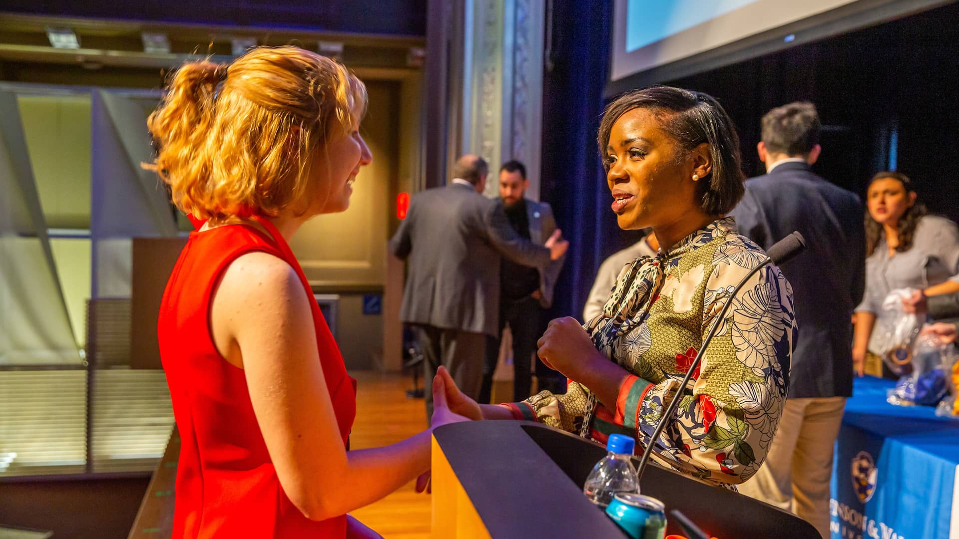 Alumni Pearl Farquharson '12 talking with a student