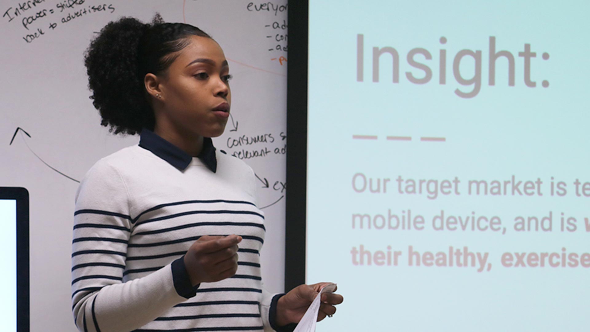 A Johnson & Wales advertising student presenting Amazon Account Executive presentation in front of a Powerpoint screen