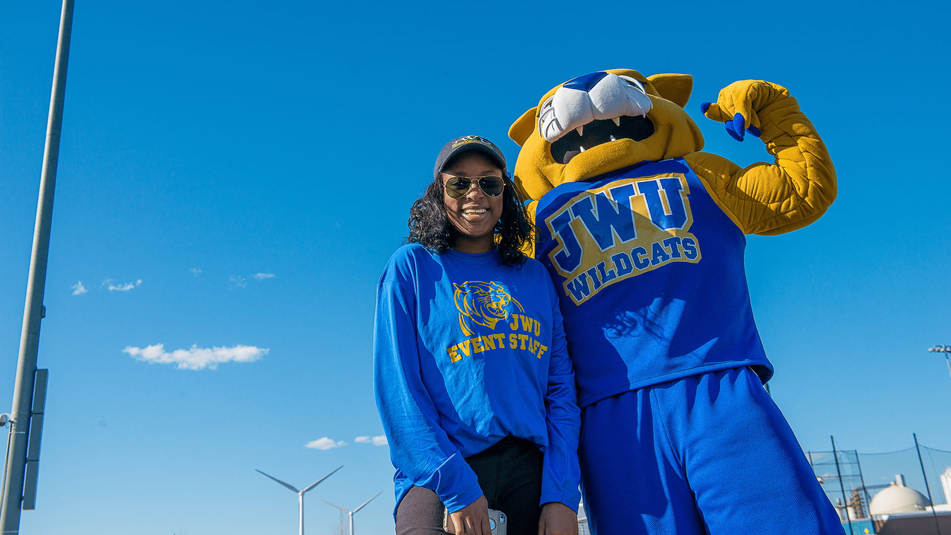 Wildcat Willy posing for a photo with a student