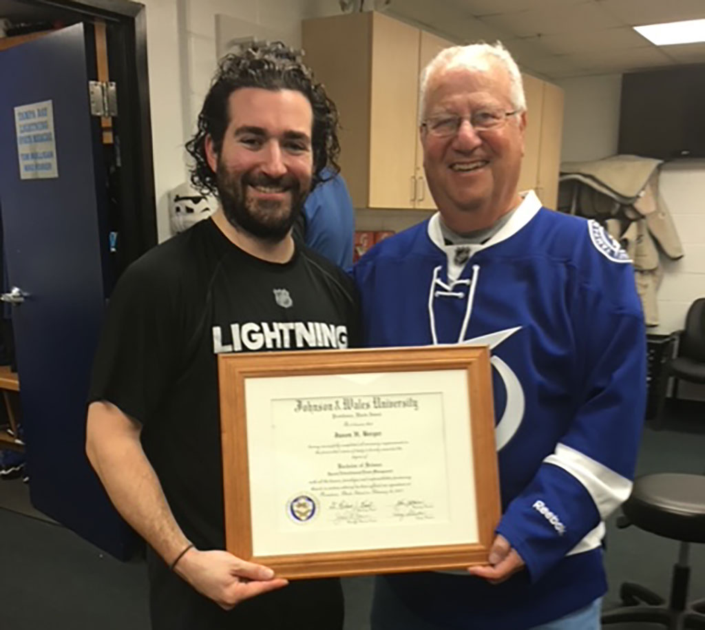 Jason Berger and former JWU Providence Campus President Irving Schneider pose with Berger's JWU diploma