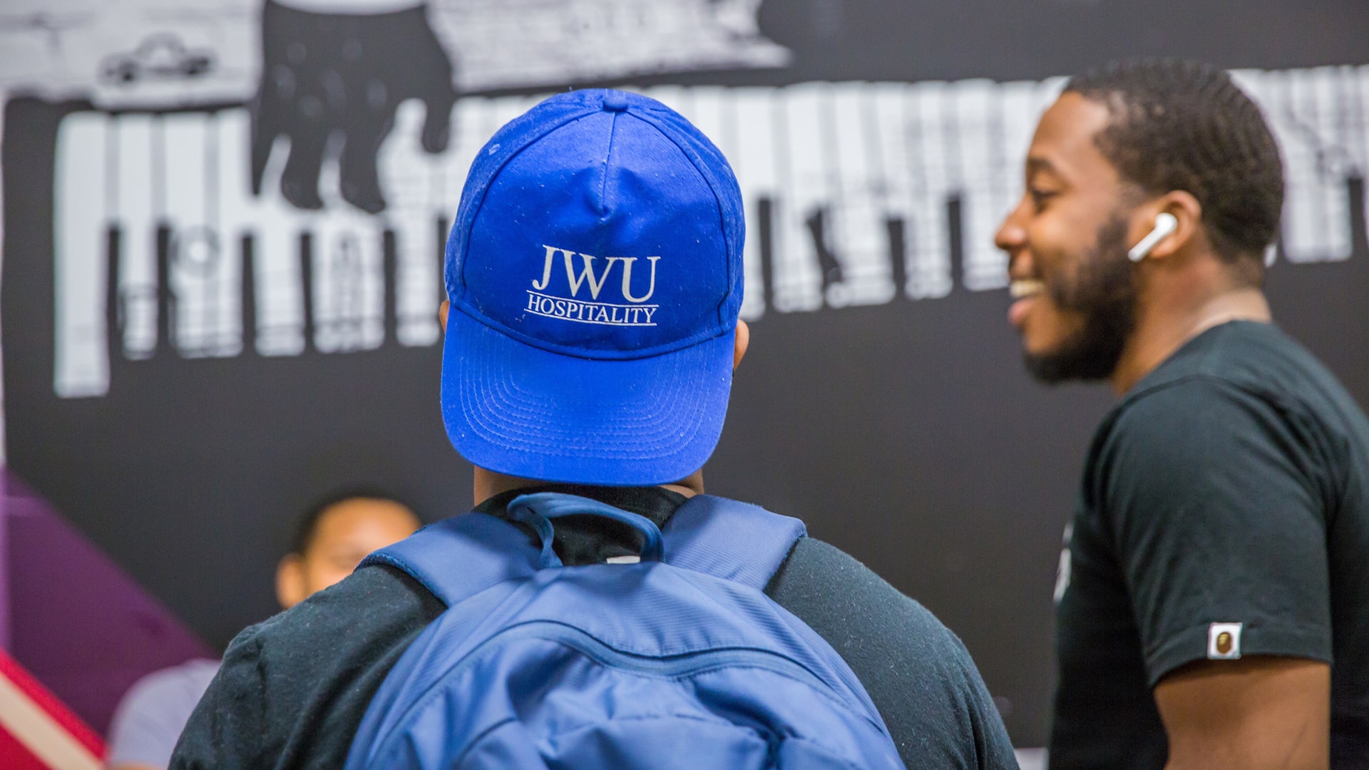 Backview of student wearing a JWU Hospitality hat