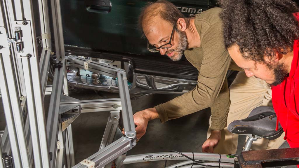 Associate Professor Jonathan Harris works with Sebastian Silva ’20 on a bike cart prototype.