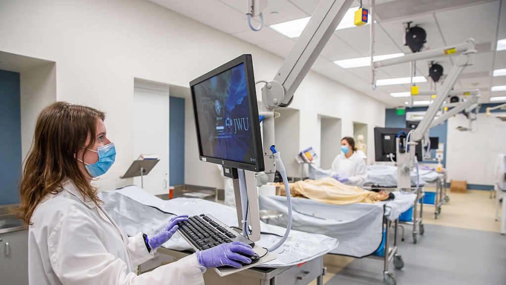 JWU student in physician assistant lab working on computer