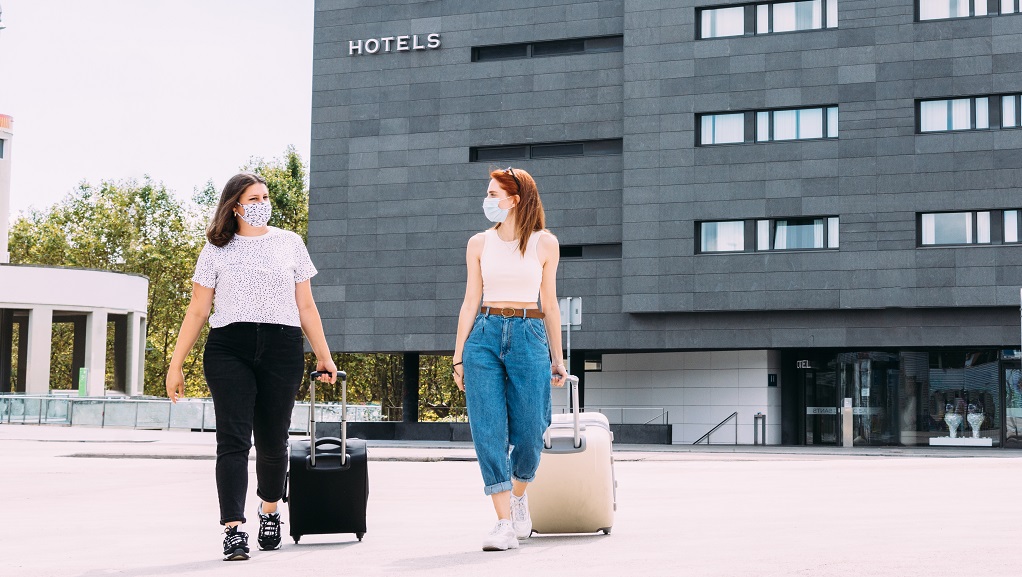 Two females leave hotel wearing masks