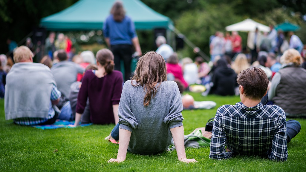 Couple sits on blanket at outdoor event