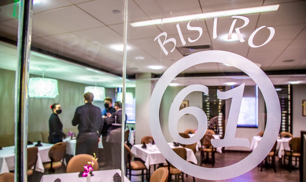 The window of JWU’s Bistro 61 with students standing inside 